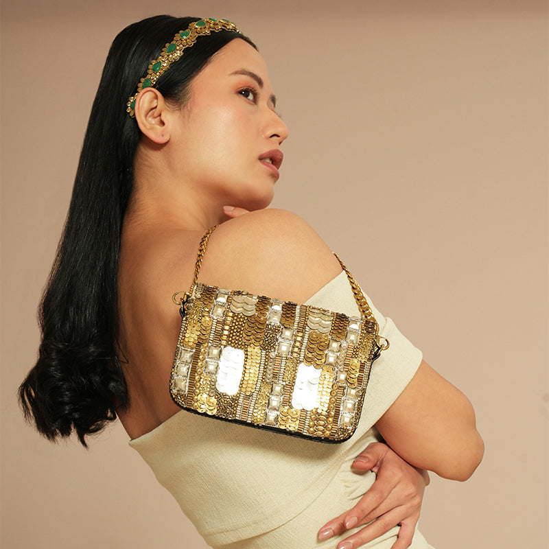 Model holding Deepa Gurnani Vahana Clutch in Gold/Silver color