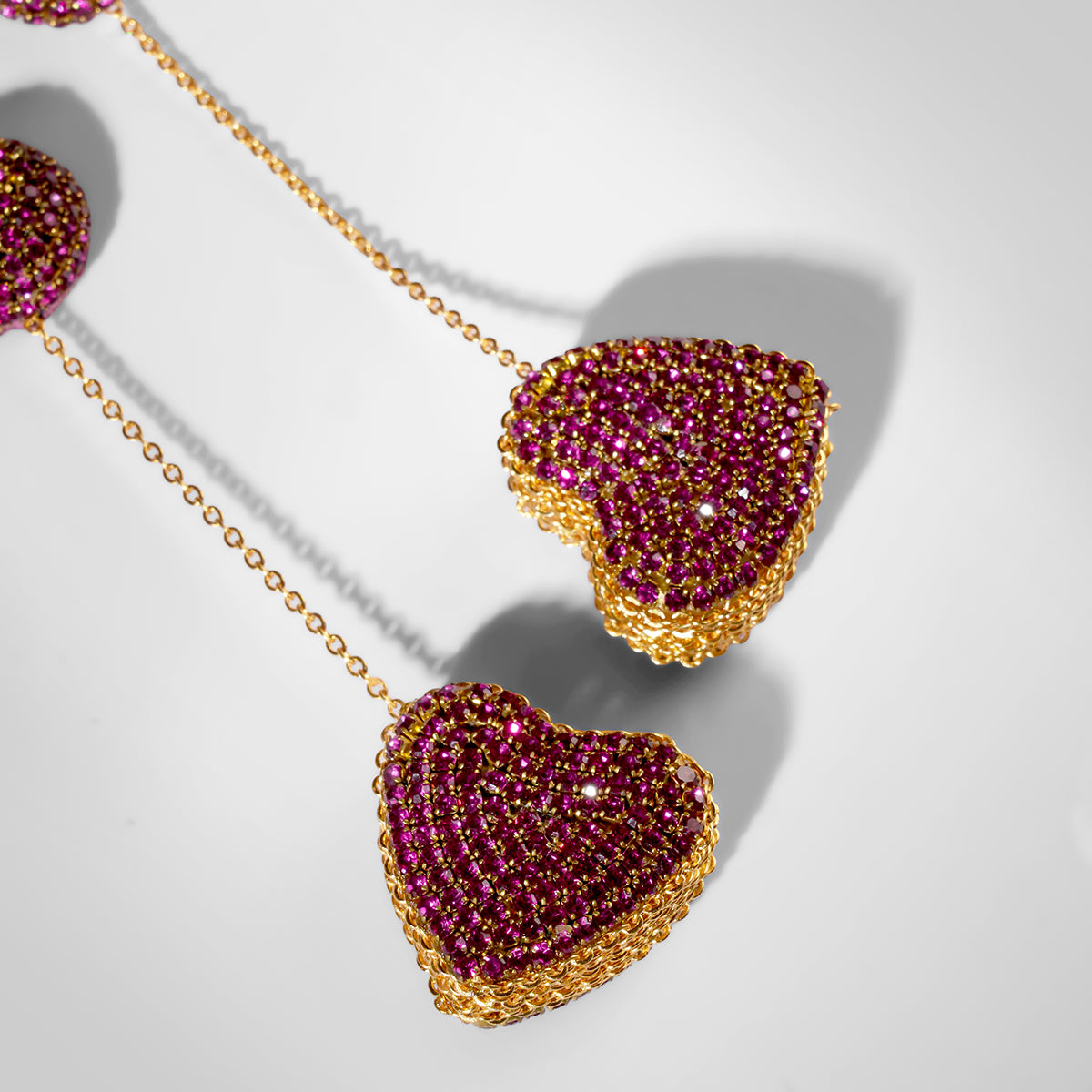 Close up of Deepa Gurnani Eros Earrings in fuchsia color