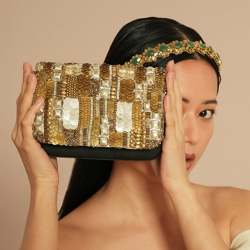 Model holding Deepa Gurnani Vahana Clutch in Gold/Silver color 
