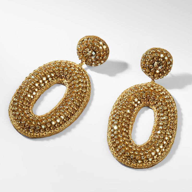 Pair of gold earrings on a light gray background