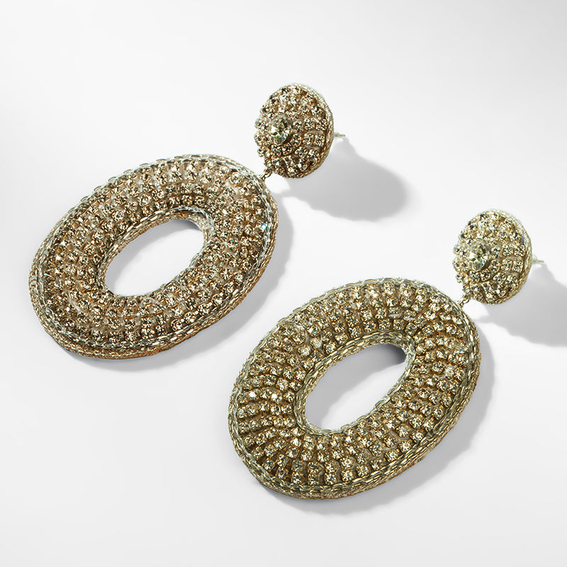 Gold hoop earrings with a textured design on a white background