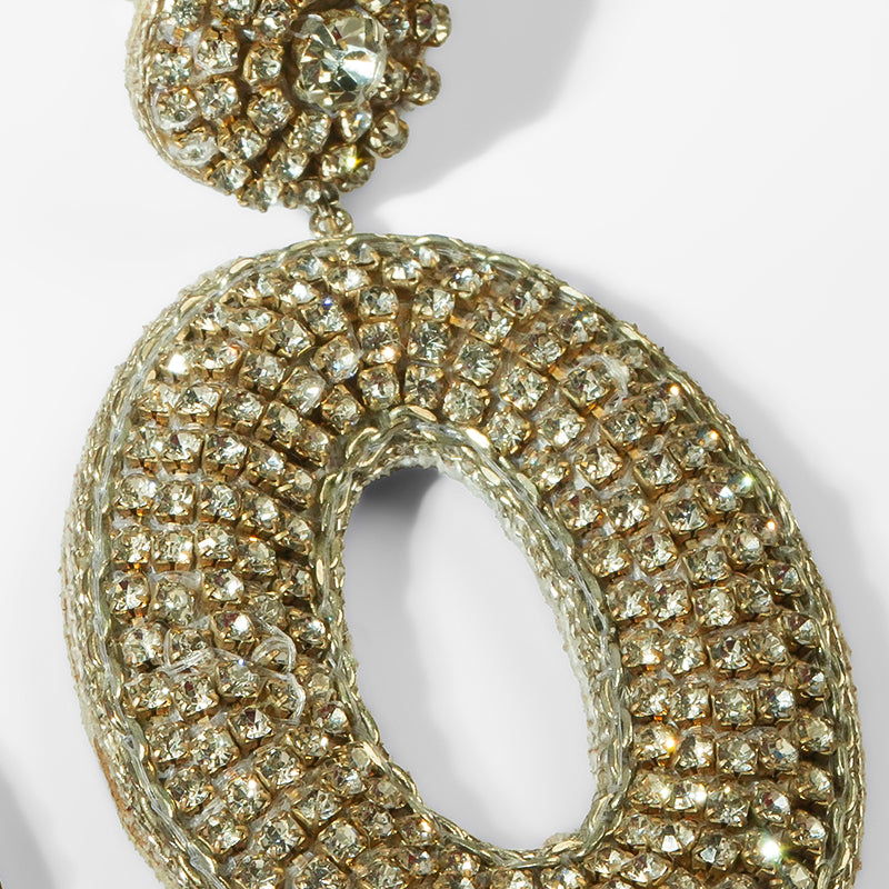 Gold hoop earring with diamond-like stones on a white background