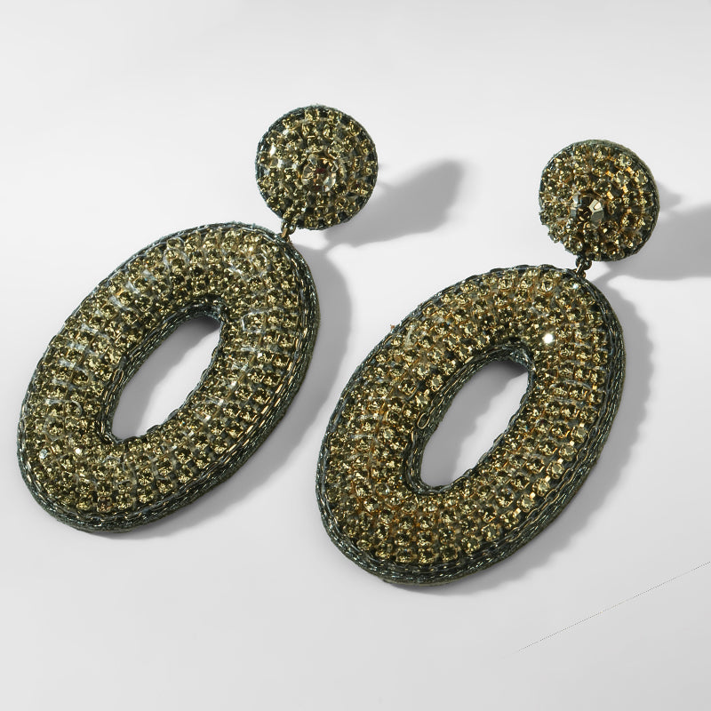 Pair of gunmetal glittery earrings on a white background