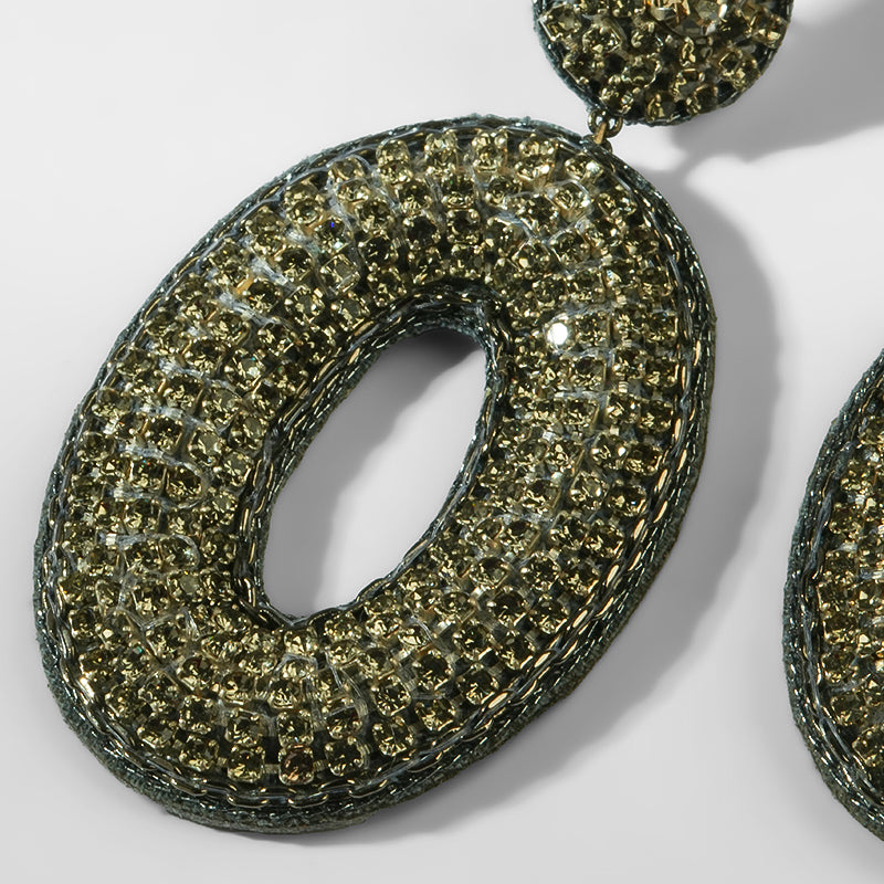 Close-up of a textured gold earring on a light background