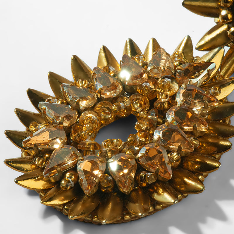 Gold spike earrings on a white background