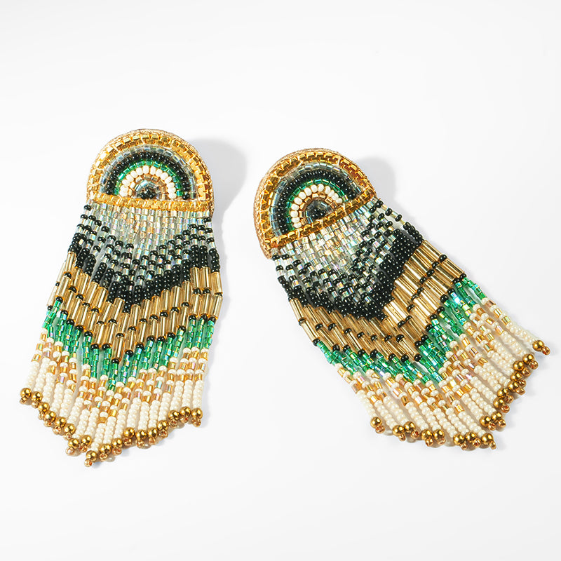 Beaded earrings with gold, green, and black pattern on a white background