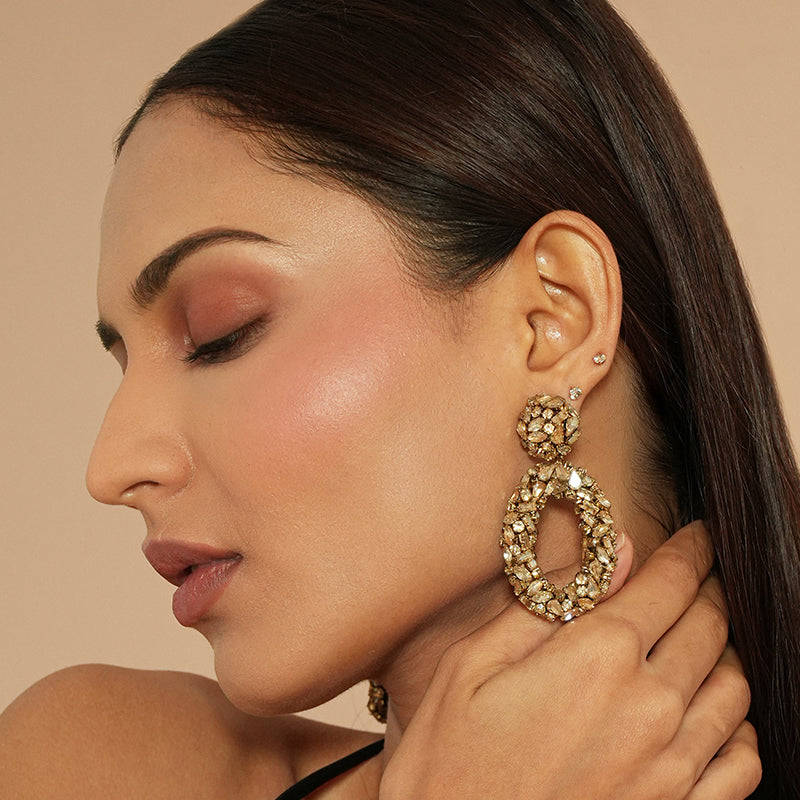 Model wearing Deepa Gurnani Dinorah Earrings in Gold color