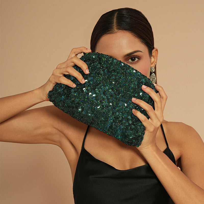 Model holding Deepa Gurnani Hermia Clutch in Emerald color