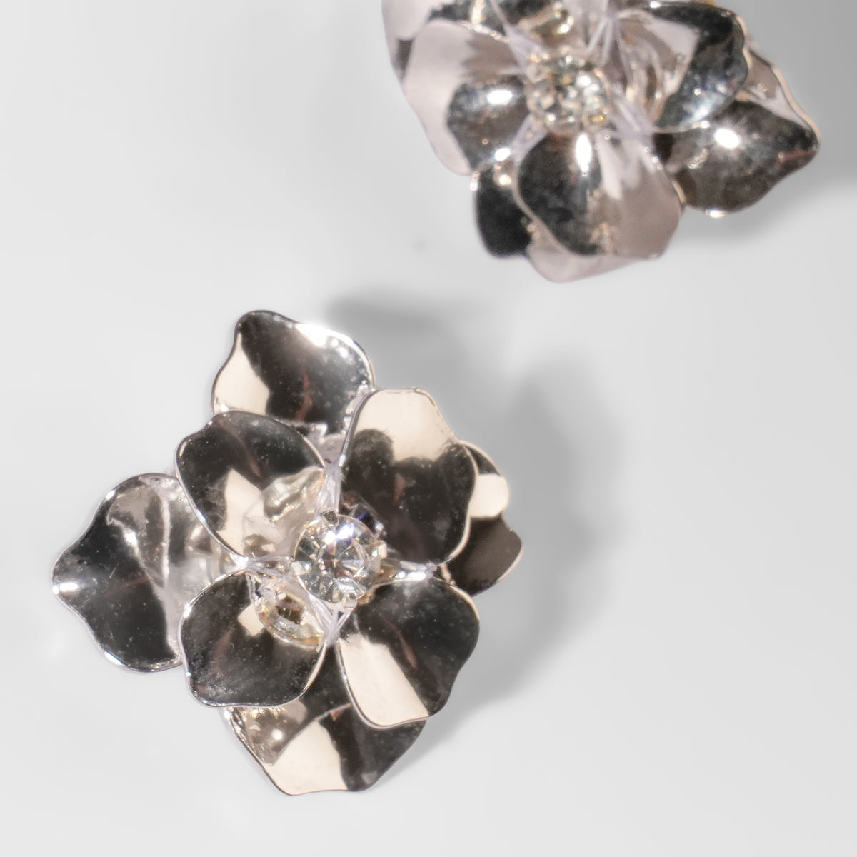 close up of Deepa Gurnani Pret Siran Earrings in silver color